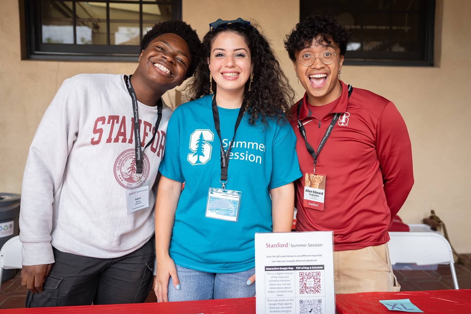 Three students stand together, smiling.