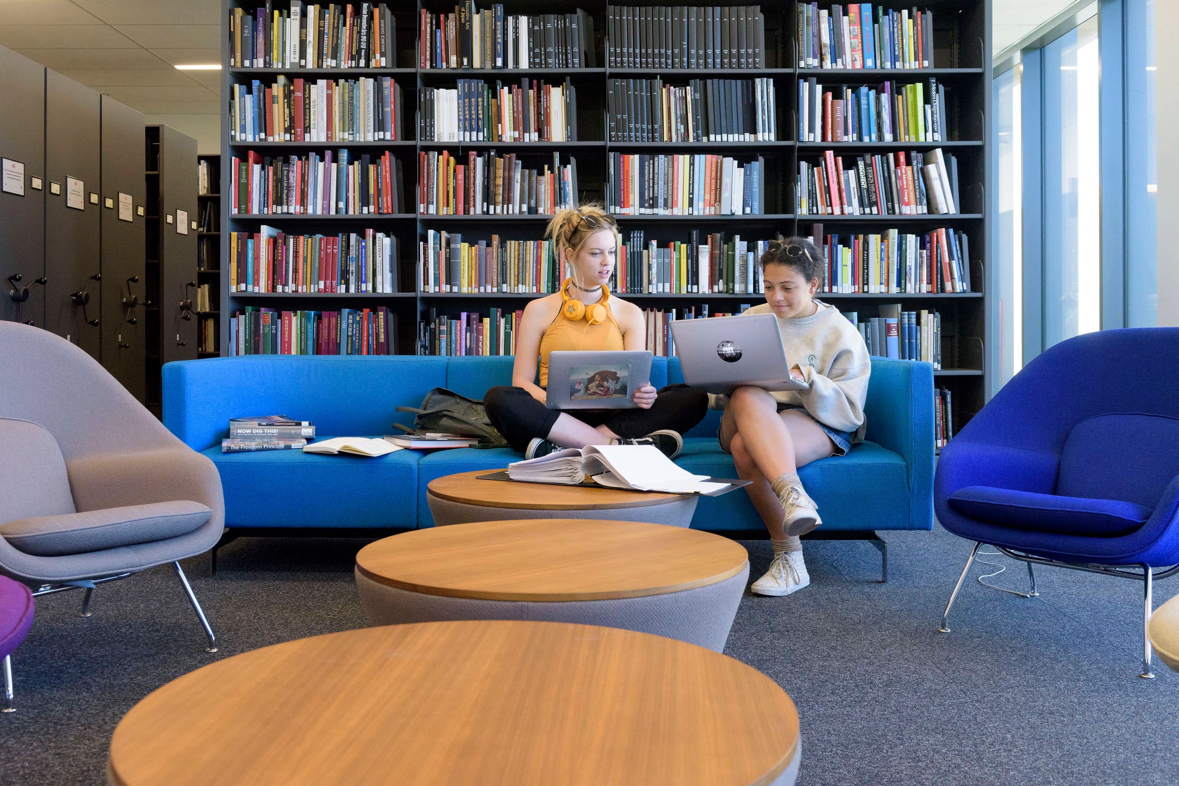 Students study on a sofa in a library.