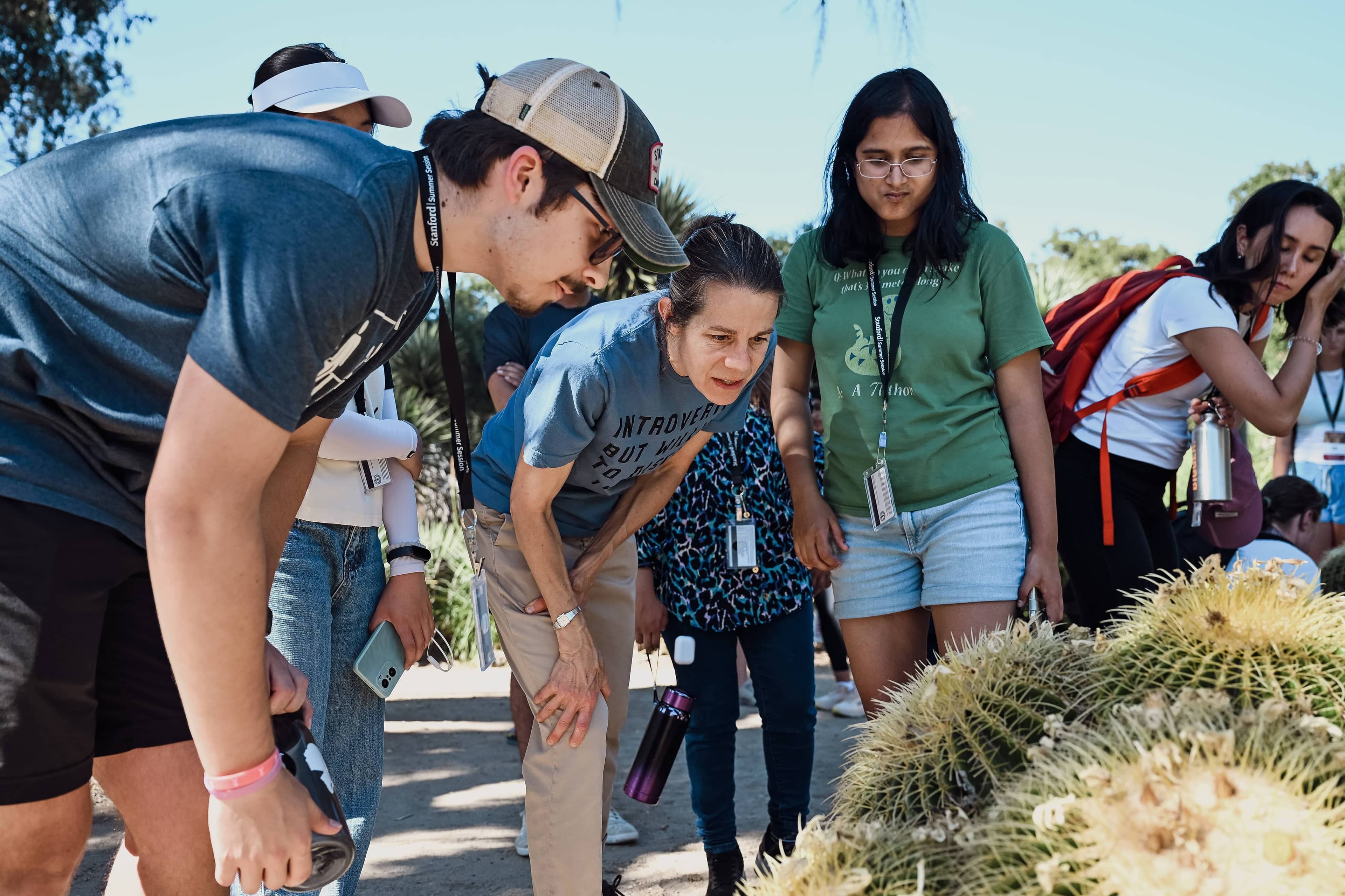 Students gather with Dr. Katherine Preston to look at a cactus in the Arizona Cactus Garden.